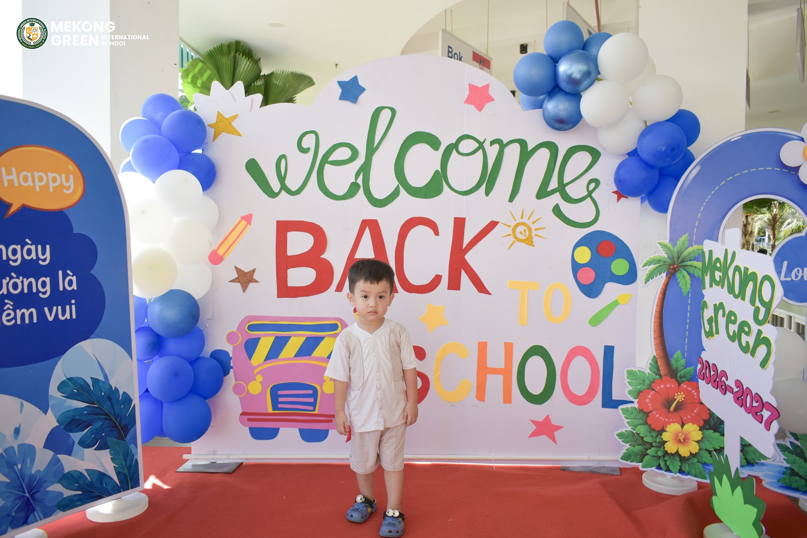 Bé tạo dáng tại backdrop Welcome Back to School 2026-2027